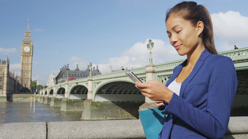 Mujer de negocios de telefonía que usa sms para smartphones usando una aplicación en londres