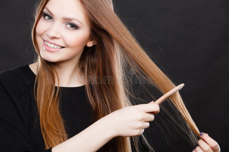 Healthy look concept. Girl combing brushing her hair by using wooden comb. Young woman taking care of everyday hygiene and natural beauty. Healthy look concept. Girl combing brushing her hair by using wooden comb. Young woman taking care of everyday hygiene and natural beauty.