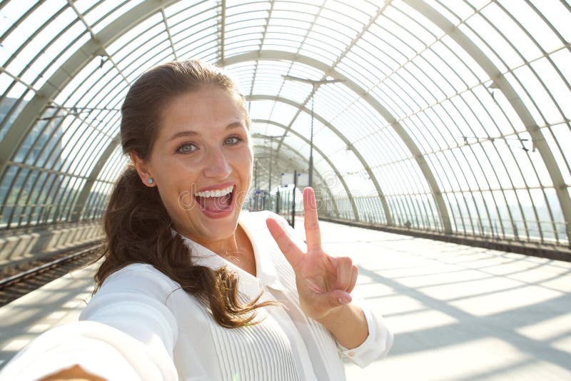 Mujer de risa joven que toma el selfie con el signo de la paz fotografía de archivo