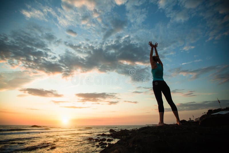 Mujer de yoga haciendo ejercicio en la costa del océano imágenes de archivo libres de regalías Mujer de yoga haciendo ejercicio en la costa del océano imágenes de archivo libres de regalías