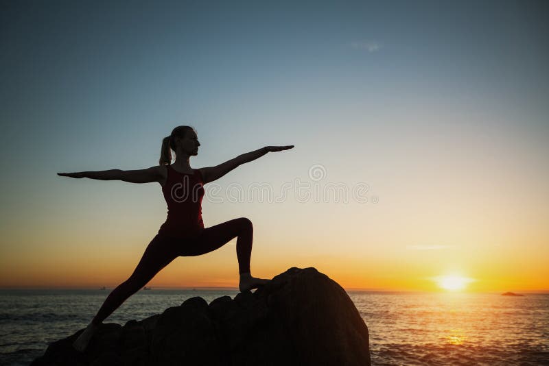 Mujer de yoga silueta haciendo ejercicios de fitness cerca del mar al atardecer Deporte fotos de archivo libres de regalías Mujer de yoga silueta haciendo ejercicios de fitness cerca del mar al atardecer Deporte fotos de archivo libres de regalías
