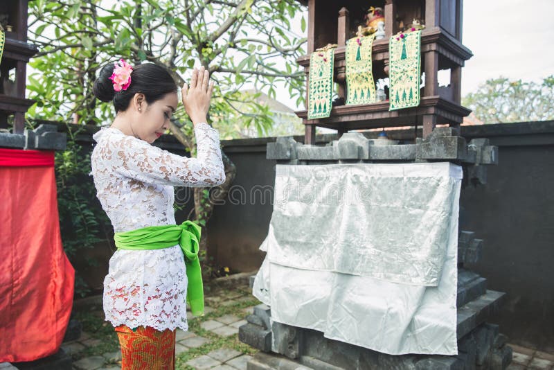 Mujer del Balinese que hace la sari de ofrecimiento del canang del ritual y que ruega en imagenes de archivo Mujer del Balinese que hace la sari de ofrecimiento del canang del ritual y que ruega en imagenes de archivo
