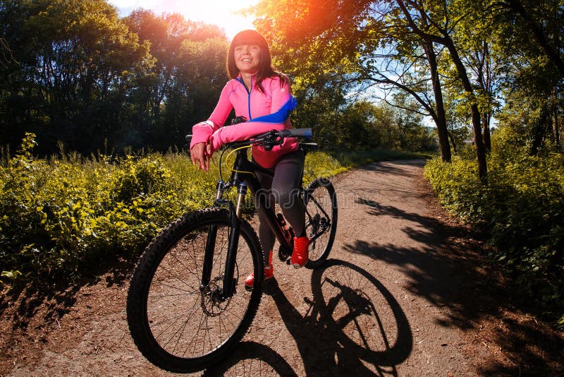 Mujer del ciclista que monta una bicicleta en parque fotos de archivo libres de regalías Mujer del ciclista que monta una bicicleta en parque fotos de archivo libres de regalías