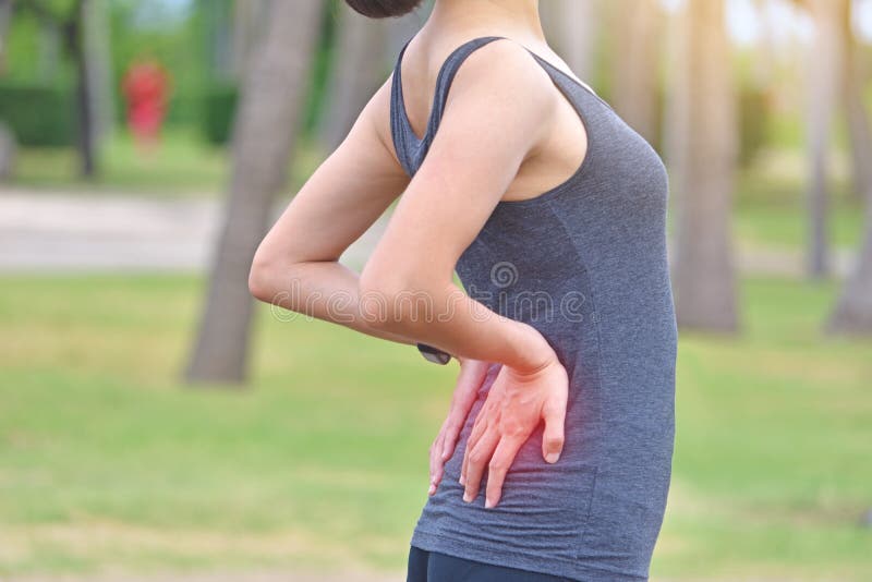 Mujer del deporte con dolor de espalda en un parque fotografía de archivo