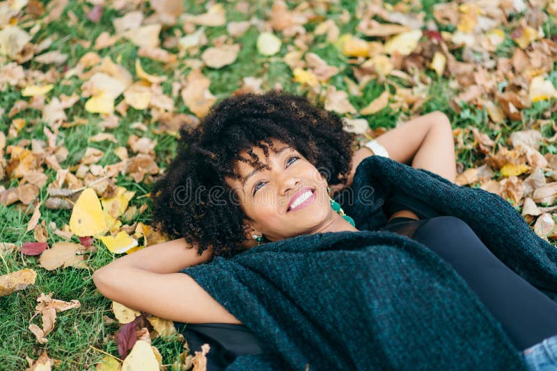 Mujer del estilo de pelo del Afro daydraming en otoño