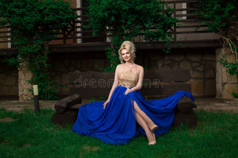 Mujer del modelo de moda que presenta el vestido de noche largo atractivo, que lleva imagen de archivo Mujer del modelo de moda que presenta el vestido de noche largo atractivo, que lleva imagen de archivo
