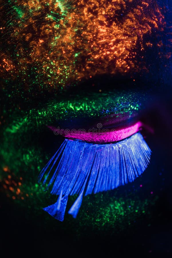 Cara de mujer en la oscuridad con pintura fluorescente maquillaje  sosteniendo un velo blanco bajo las luces negras deep blue Fotografía de  stock - Alamy