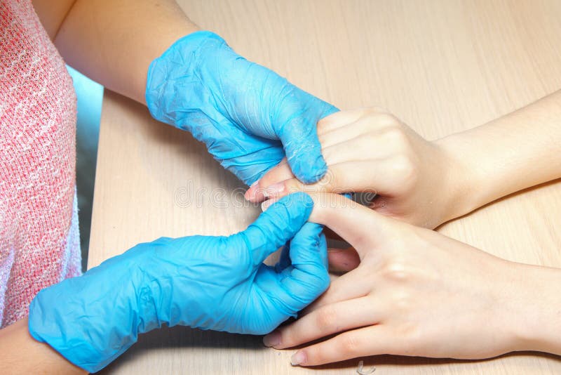 Mujer del primer en un sal?n del clavo que recibe una manicura de un cosmet?logo Clavos del fichero del cosmet?logo a un cliente fotos de archivo Mujer del primer en un sal?n del clavo que recibe una manicura de un cosmet?logo Clavos del fichero del cosmet?logo a un cliente fotos de archivo