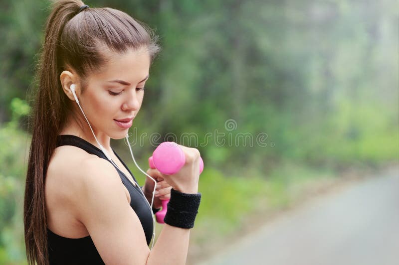 Mujer deportiva de la aptitud sana de la forma de vida con pesa de gimnasia y headpho fotografía de archivo libre de regalías Mujer deportiva de la aptitud sana de la forma de vida con pesa de gimnasia y headpho fotografía de archivo libre de regalías