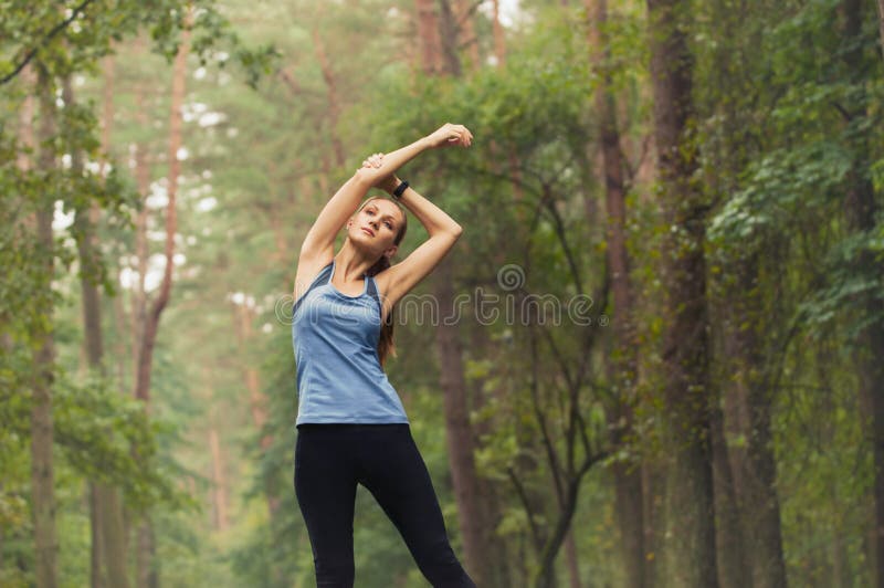 Mujer deportiva de la aptitud sana de la forma de vida que estira antes de funcionamiento adentro imagen de archivo libre de regalías Mujer deportiva de la aptitud sana de la forma de vida que estira antes de funcionamiento adentro imagen de archivo libre de regalías