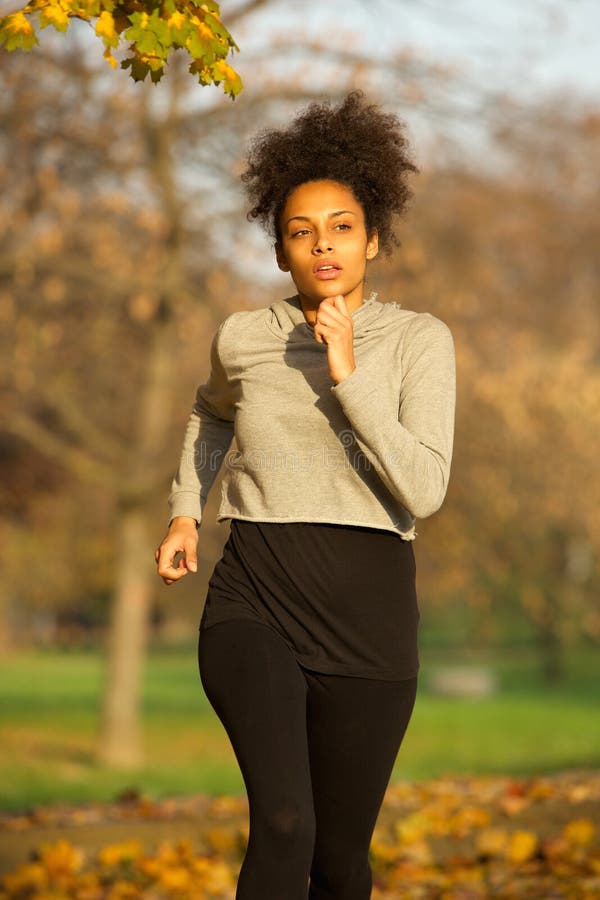 Mujer deportiva joven que corre al aire libre en el parque imagen de archivo libre de regalías Mujer deportiva joven que corre al aire libre en el parque imagen de archivo libre de regalías