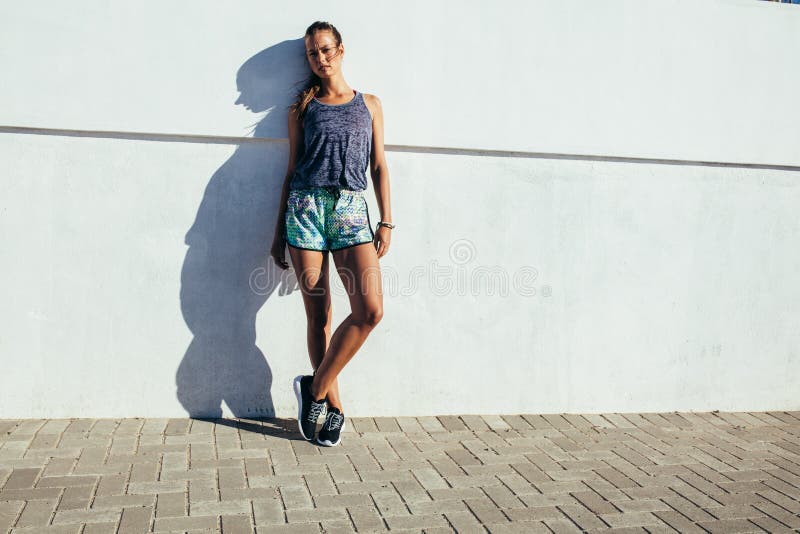 Mujer deportiva que se relaja después de entrenamiento corriente foto de archivo libre de regalías Mujer deportiva que se relaja después de entrenamiento corriente foto de archivo libre de regalías