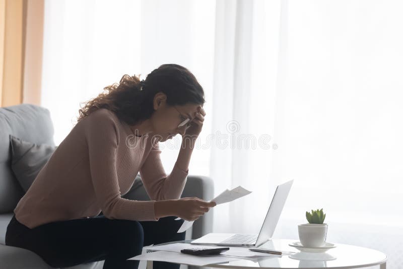 Mujer deprimida usando anteojos calculando facturas problema financiero fotos de archivo