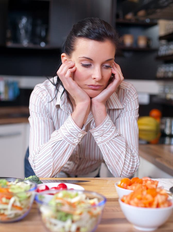 Mujer deprimida y triste en cocina imagen de archivo libre de regalías Mujer deprimida y triste en cocina imagen de archivo libre de regalías