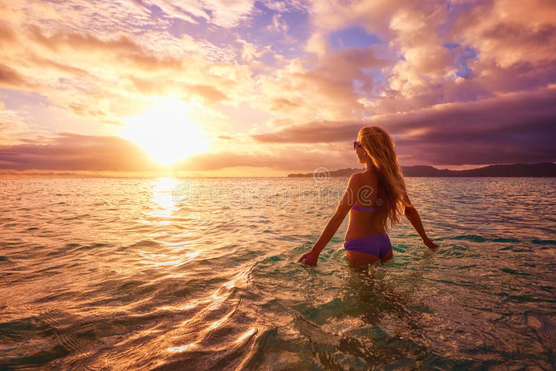 Mujer despreocupada en la puesta del sol en la playa hea de la vitalidad de las vacaciones fotografía de archivo libre de regalías Mujer despreocupada en la puesta del sol en la playa hea de la vitalidad de las vacaciones fotografía de archivo libre de regalías