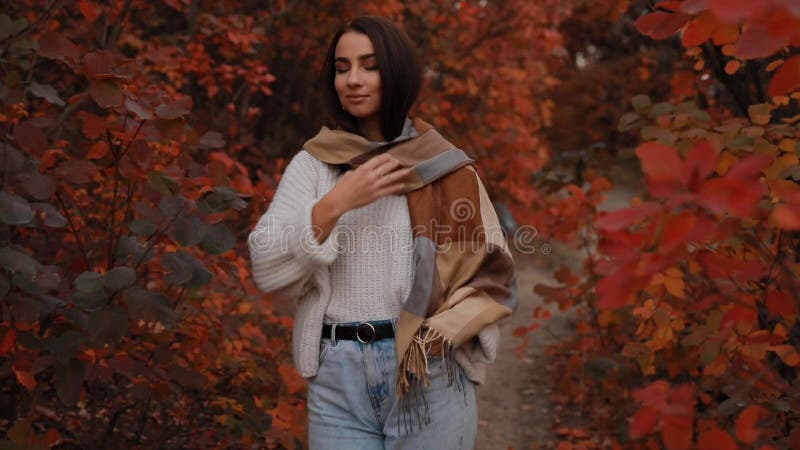 Mujer disfrutando el dÃ­a de otoÃ±o, camina en el bosque, coloridas follajes por ahÃ­, cÃ¡mara lenta