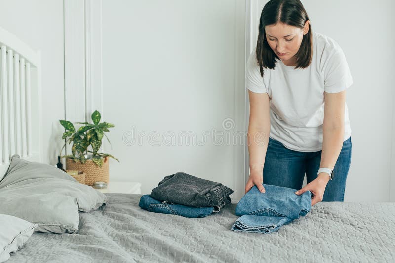 Mujer Doblando Ropa Jeans. Concepto De Desorden De Actualización De  Primavera De Análisis De Armario. Estilo De Vida Foto de archivo - Imagen  de dormitorio, clasificado: 210876002