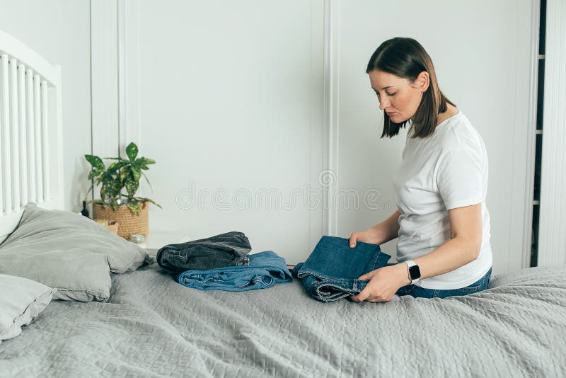 Mujer Doblando Ropa Jeans. Concepto De Desorden De Actualización De  Primavera De Análisis De Armario. Estilo De Vida Foto de archivo - Imagen  de persona, manera: 210876026