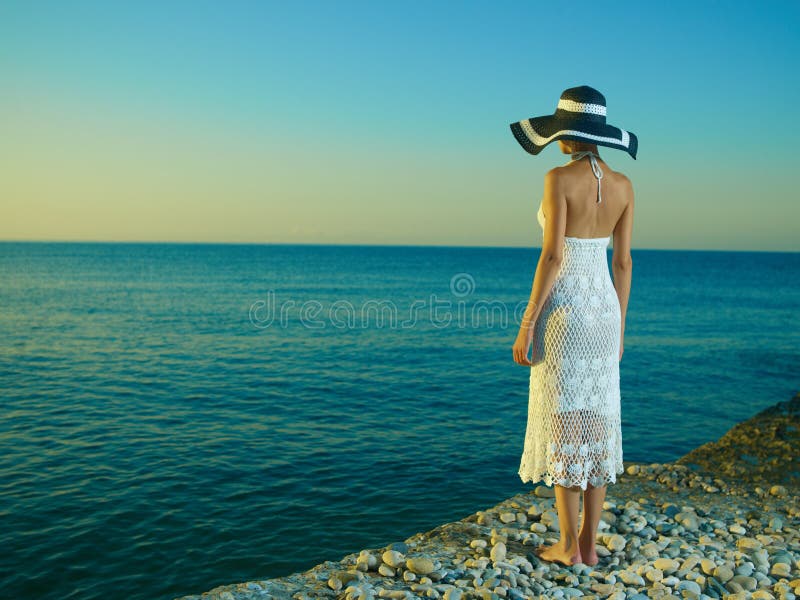 Mujer elegante en un sombrero en el mar imágenes de archivo libres de regalías Mujer elegante en un sombrero en el mar imágenes de archivo libres de regalías