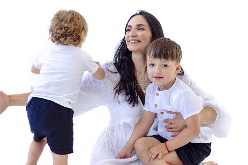 Mujer embarazada con vestido blanco juega con sus hijos pequeños. la atractiva madre sonríe y abraza a sus hijos. blanco aislado imágenes de archivo libres de regalías