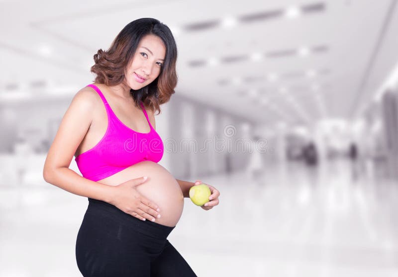 Mujer embarazada hermosa con la manzana verde en hospital imagenes de archivo Mujer embarazada hermosa con la manzana verde en hospital imagenes de archivo