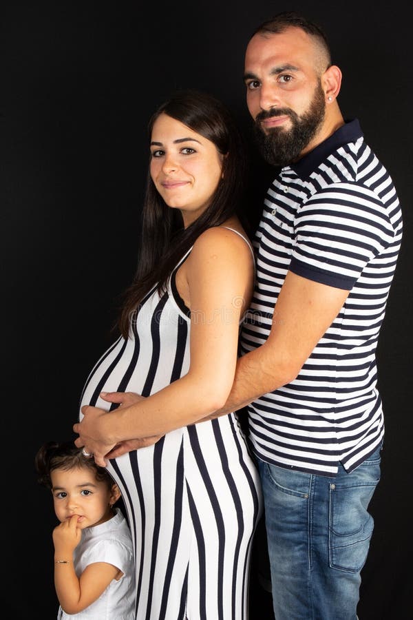 Mujer embarazada joven con su embarazo de la hija y de la madre del padre de la familia fotografía de archivo libre de regalías Mujer embarazada joven con su embarazo de la hija y de la madre del padre de la familia fotografía de archivo libre de regalías