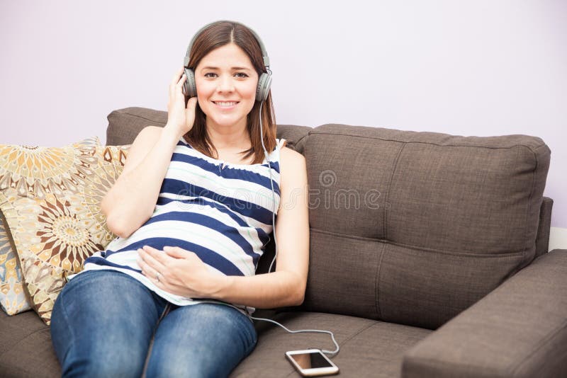 Mujer embarazada que escucha la música foto de archivo libre de regalías Mujer embarazada que escucha la música foto de archivo libre de regalías