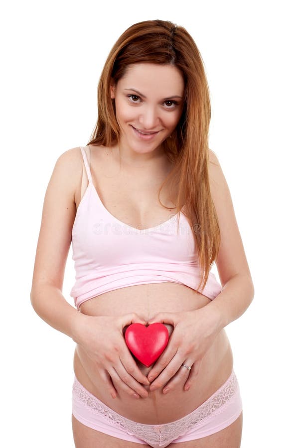 Mujer embarazada que lleva a cabo el corazón rojo imagen de archivo libre de regalías Mujer embarazada que lleva a cabo el corazón rojo imagen de archivo libre de regalías