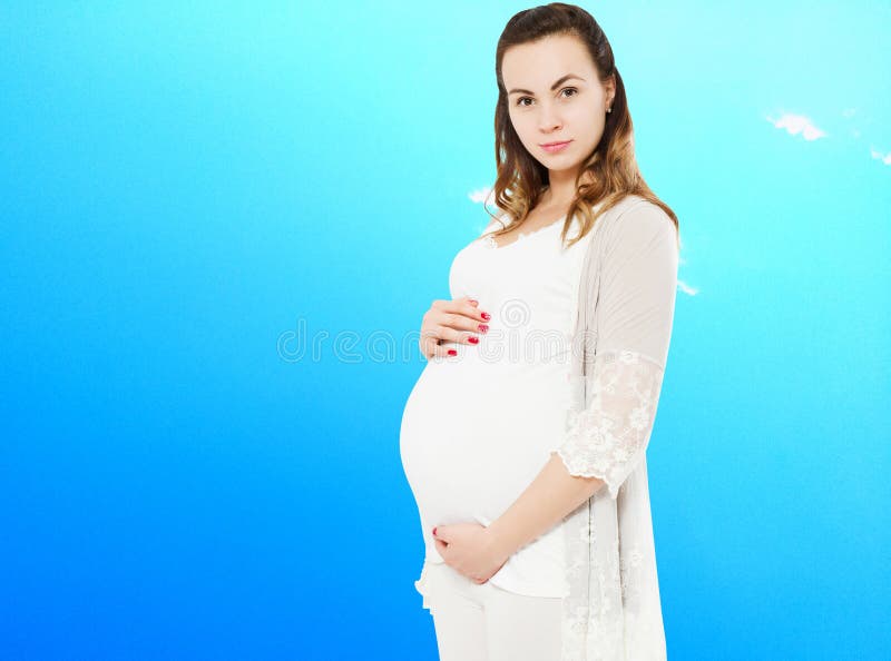 Mujer embarazada vestida de forma casual con un fondo del cielo borroso, mujer embarazada con ropa informal aislada de fondo azul fotografía de archivo libre de regalías Mujer embarazada vestida de forma casual con un fondo del cielo borroso, mujer embarazada con ropa informal aislada de fondo azul fotografía de archivo libre de regalías