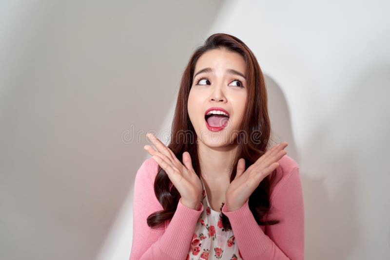 Mujer emocional joven sorprendida y feliz que mira emocionado aislado en el fondo blanco en estudio fotografía de archivo libre de regalías Mujer emocional joven sorprendida y feliz que mira emocionado aislado en el fondo blanco en estudio fotografía de archivo libre de regalías