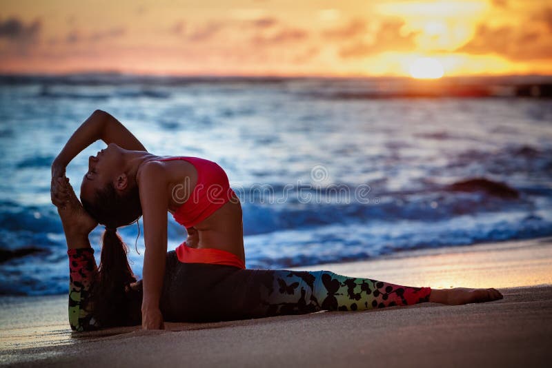 Mujer en actitud de la yoga en la playa del mar de la puesta del sol fotografía de archivo libre de regalías Mujer en actitud de la yoga en la playa del mar de la puesta del sol fotografía de archivo libre de regalías
