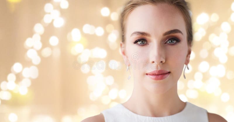 Mujer en el vestido blanco con el pendiente del diamante foto de archivo libre de regalías Mujer en el vestido blanco con el pendiente del diamante foto de archivo libre de regalías