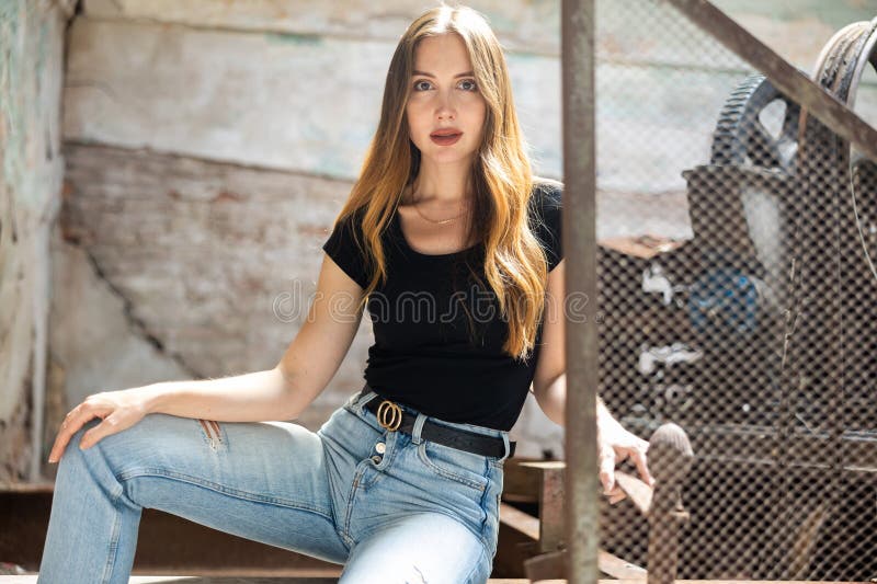 Mujer En Jeans Y Camiseta Negra Posando Cerca De La Cerca De Malla Acero En Planta Imagen archivo - Imagen aspecto, lanzamiento: 276620717