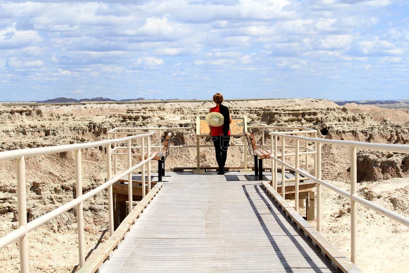 Mujer en la calzada en los Badlands parque nacional, Dakota del Sur foto de archivo Mujer en la calzada en los Badlands parque nacional, Dakota del Sur foto de archivo