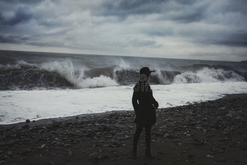 Mujer en la playa durante una tormenta foto de archivo Mujer en la playa durante una tormenta foto de archivo