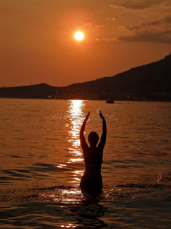 Mujer en la puesta del sol en el mar 1 foto de archivo Mujer en la puesta del sol en el mar 1 foto de archivo