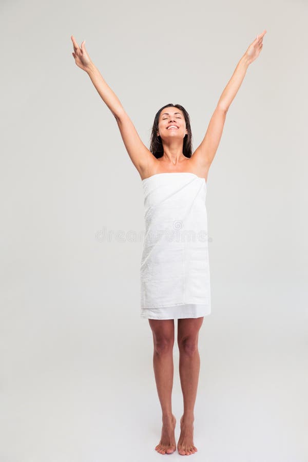 Mujer en la toalla que se coloca con las manos aumentadas para arriba