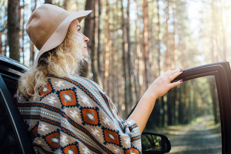 Mujer En Puerta Coche De Apertura Del Sombrero De Fieltro De Ala Ancha Y Del Poncho Auténtico En El Bosque Del árbo Foto de - de manera, libertad: