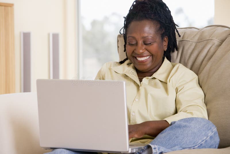 Mujer en sala de estar usando la computadora portátil fotos de archivo libres de regalías Mujer en sala de estar usando la computadora portátil fotos de archivo libres de regalías