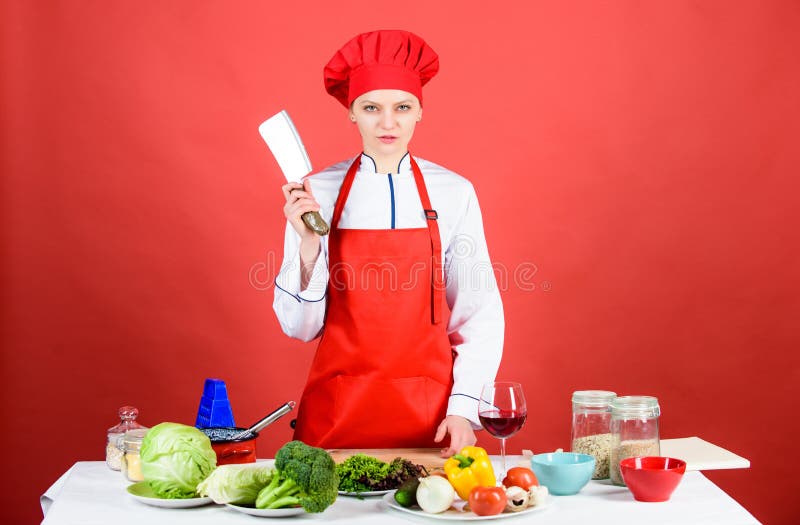 Mujer en sombrero del cocinero con el cuchillo La cena de boda con la carne del rodillo fum? y los tomates dieting mujer seria qu fotos de archivo libres de regalías Mujer en sombrero del cocinero con el cuchillo La cena de boda con la carne del rodillo fum? y los tomates dieting mujer seria qu fotos de archivo libres de regalías