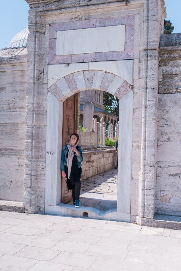 Mujer en una chaqueta del dril de algodón en una cerca de piedra foto de archivo libre de regalías Mujer en una chaqueta del dril de algodón en una cerca de piedra foto de archivo libre de regalías