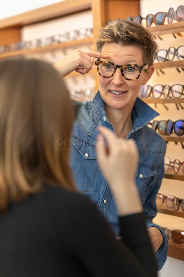 Mujer en una tienda de las gafas imágenes de archivo libres de regalías Mujer en una tienda de las gafas imágenes de archivo libres de regalías