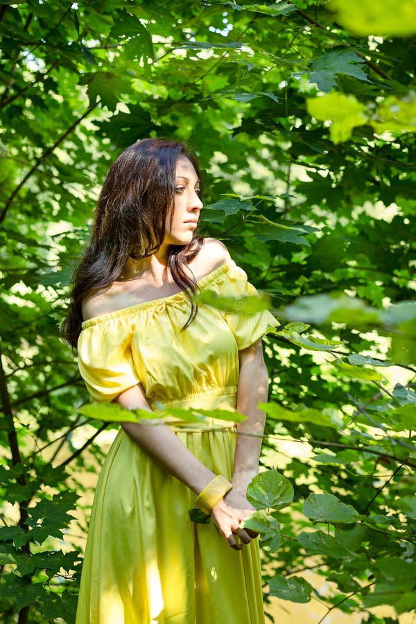 Mujer en vestido amarillo en el bosque el concepto de expectativa foto de archivo Mujer en vestido amarillo en el bosque el concepto de expectativa foto de archivo