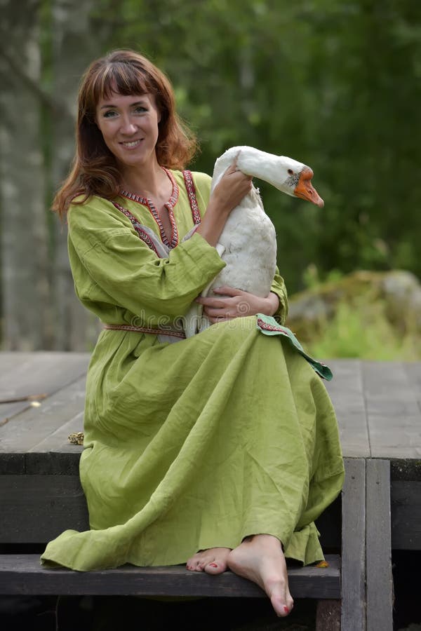 Mujer En Vestido Verde Con En Sus Brazos Foto de archivo - de ganso, hermoso: 145935432