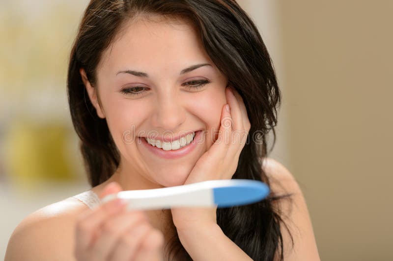 Mujer encantada que lleva a cabo la prueba de embarazo