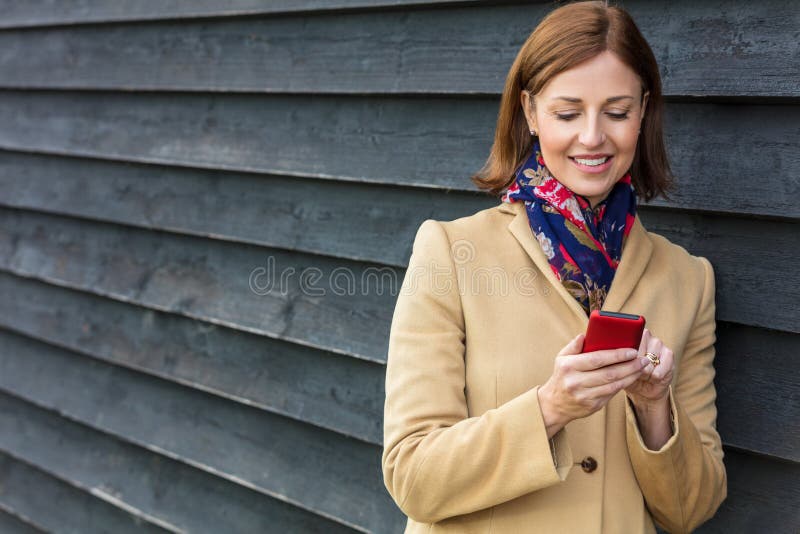 Mujer envejecida centro que usa el teléfono celular móvil fotografía de archivo libre de regalías Mujer envejecida centro que usa el teléfono celular móvil fotografía de archivo libre de regalías
