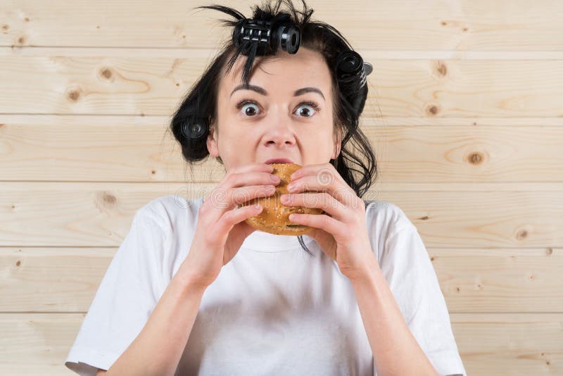 Mujer fea que come una hamburguesa imagen de archivo Mujer fea que come una hamburguesa imagen de archivo