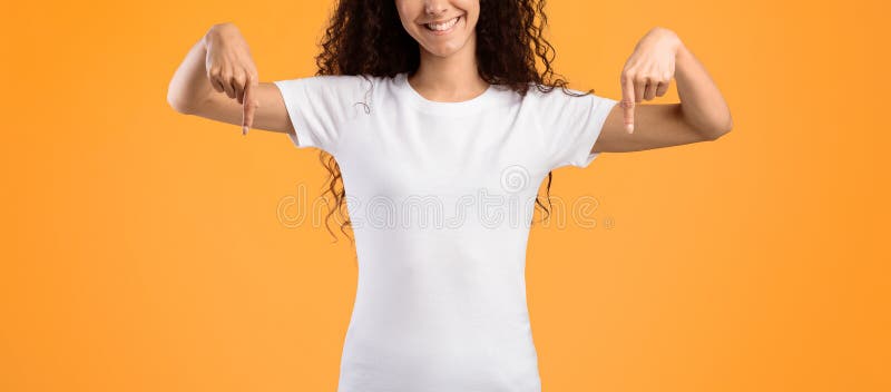 Mujer feliz con el curry apuntando los dedos sobre el fondo amarillo imagenes de archivo