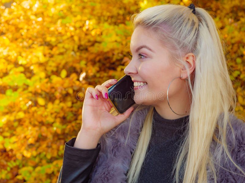 Mujer feliz hablando con el teléfono móvil al aire libre imagenes de archivo