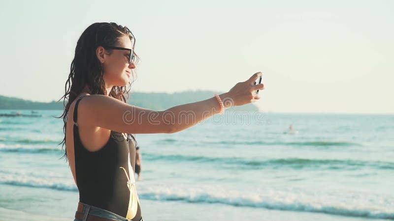 Mujer feliz haciendo selfie en la playa